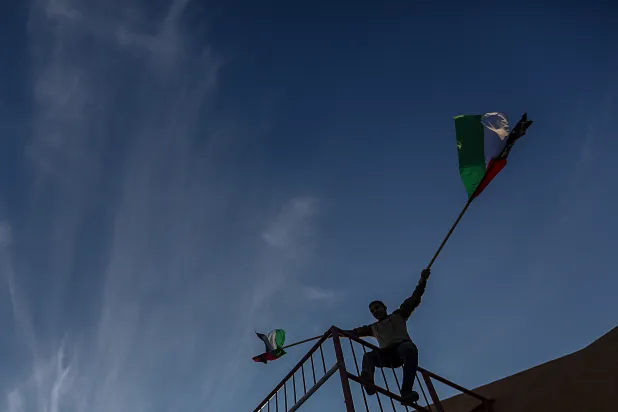 شاب يرفع علم «حماس» خلال مهرجان بغزة في 14 أبريل الماضي (إ.ب.أ)