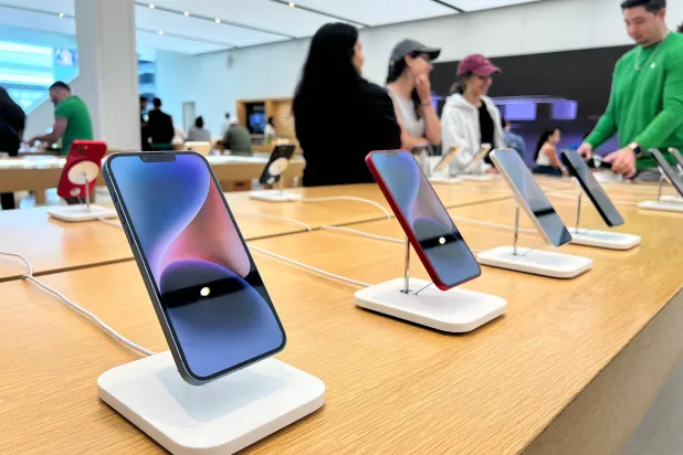 زبائن يفحصون منتجات لشركة أبل في متجرها بميامي في ولاية فلوريدا الأميركية (أ ف ب)