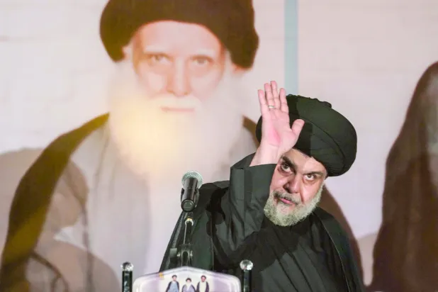 مقتدى الصدر يحيي أنصاره أول من أمس خلال مراسم إحياء ذكرى اغتيال والده في مدينة النجف العام الماضي (أ.ف.ب)