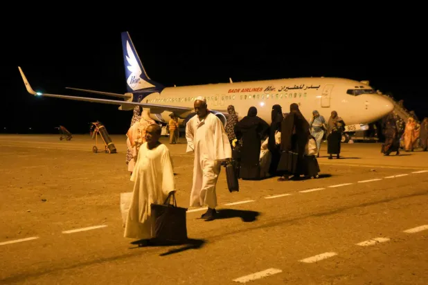 Cidde'den dönen Sudanlılar Port Sudan Uluslararası Havalimanı'nda yürüyor, Sudan, 11 Mayıs 2023 (Reuters)