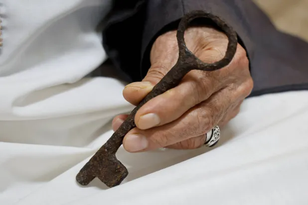 يد محمد حرب الفلسطيني في الثمانينات ومقيم في مخيم «بلاطة» تحمل مفتاحاً يعود إلى منزل أُجبرت عائلته على مغادرته بعد قيام دولة إسرائيل (رويترز)