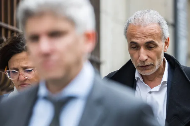 طارق رمضان (يمين) لدى وصوله إلى المحكمة بصحبة محاميه (إ.ب.أ)