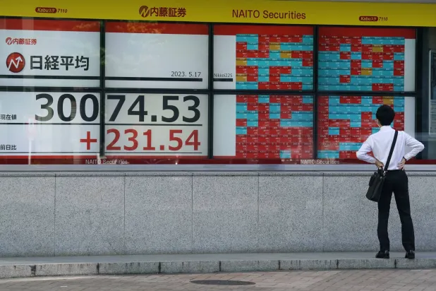 ياباني يراقب تحركات الأسهم على شاشة تعرض مستجدات مؤشر نيكي في العاصمة طوكيو (إ.ب.أ)