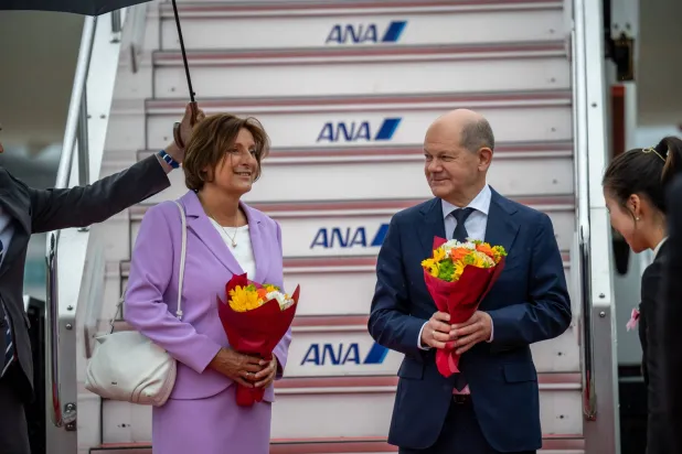 المستشار الألماني أولاف شولتس وزوجته لدى وصولهما إلى هيروشيما (د.ب.أ)