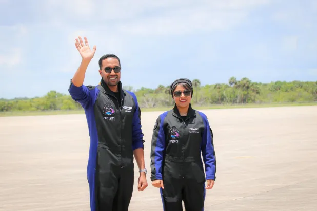 سعودی خلاباز ریانہ برناوی اور علی القرنی سفر پر روانگی سے قبل ہاتھ ہلا رہتے ہوئے