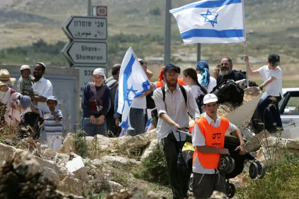 Nisan 2007’de Batı Şeria'nın kuzeyindeki Homeş Yahudi yerleşimine doğru yürüyen İsrailliler (Reuters)