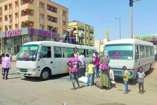 Sudanlılar dün ateşkesin başlamasından sonra güney Hartum'dan ayrılmak için otobüse biniyor (AFP)