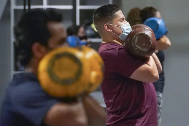 أشخاص يمارسون التمارين في أحد النوادي الرياضية بالولايات المتحدة (أ.ب)