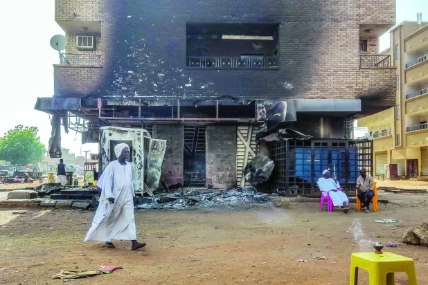 تعدادی از شهروندان جلوی شعبه آتش گرفته یکی از بانک ها در جنوب پایتخت (فرانس پرس)