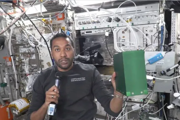 علي القرني يحمل صندوقاً أخضر لتجربة الاستمطار الصناعي داخل وحدة كولومبوس