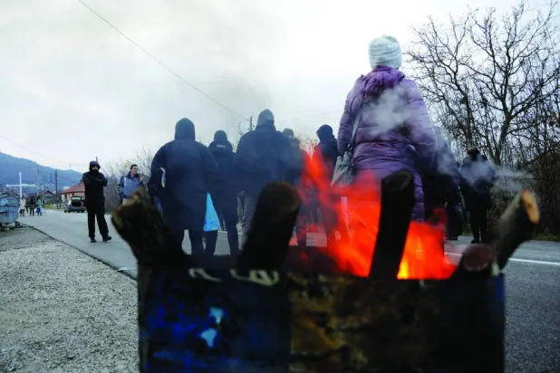 صرْب يقطعون طريقاً قرب بلدة في شمال كوسوفو (رويترز)
