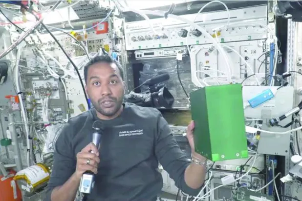 علی القرنی کولمبس یونٹ کے اندر مصنوعی بیج کے تجربے کے لیے ایک سبز باکس اٹھائے ہوئے ہیں