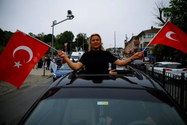 ناخبة تحتفل بعد إغلاق مكاتب الاقتراع في إسطنبول (رويترز)