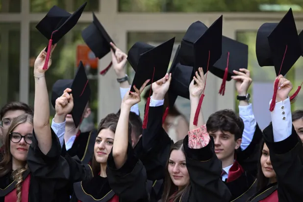 طلبة يحتفلون بتخرجهم في عاصمة مولدافيا يوم الاثنين (أ.ف.ب)