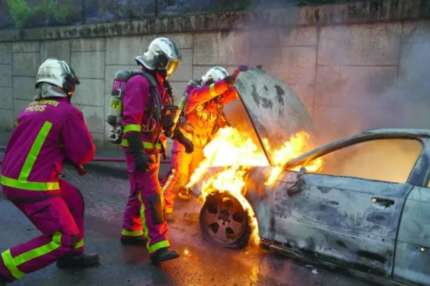 27 جون کو پیرس کے مغرب میں نانٹیرے میں جھڑپوں کے بعد فائر فائٹرز جلتی ہوئی کار کی آگ بجھا رہے ہیں (اے ایف پی)