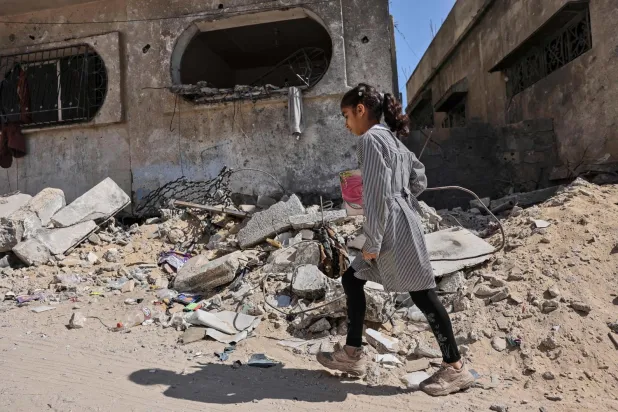 İsrail’in geçtiğimiz çarşamba günü Gazze’ye düzenlediği bombalı saldırıda vurulan bir binanın yakınındaki Filistinli bir kız öğrenci (AFP)