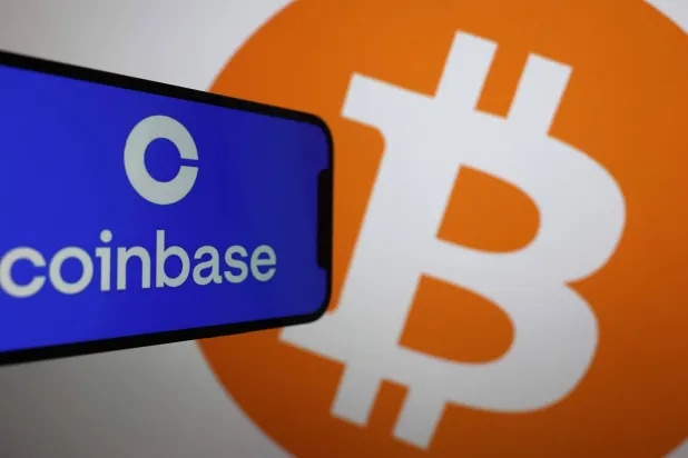 شعار منصة كوين بيز لتداول العملات المشفرة وشعار عملة بيتكوين… فيما تواجه الأولى دعوى قضائية أميركية بتهمة تعريض المستثمرين للخطر (أ.ف.ب)