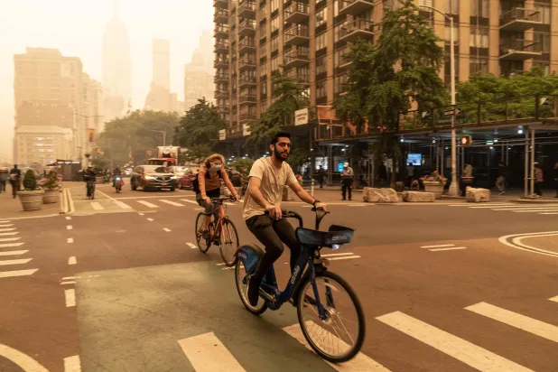 امرأة ترتدي قناع الوجه بسبب نوعية الهواء السيئة في نيويورك (د.ب.أ)