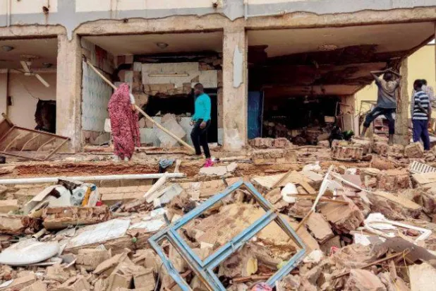 سوڈان میں جاری جھڑپوں کے دوران جنوبی خرطوم میں لوگ ایک مکان کا معائنہ کر رہے ہیں جو توپ خانے کی گولہ باری کی زد میں آنے کے بعد ملبے میں تبدیل ہو گیا ہے (اے ایف پی)