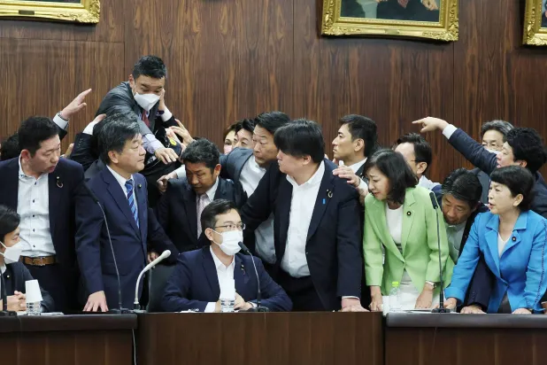 نواب المعارضة المستاؤون يحيطون برئيس لجنة تناقش الإصلاح التشريعي الخميس (أ.ف.ب)