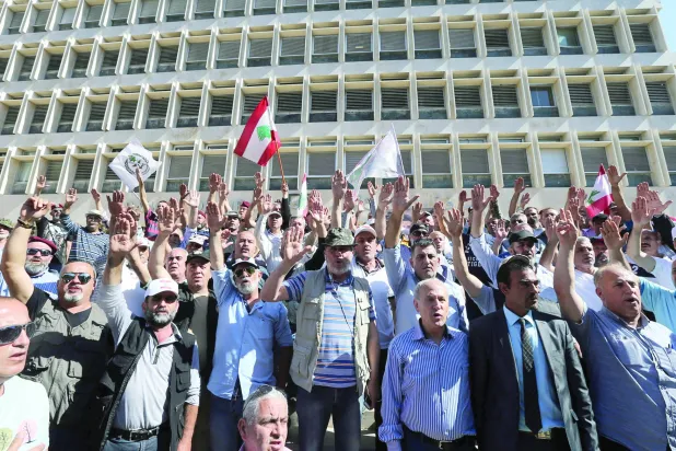 
متظاهرون أمام مقر مصرف لبنان في بيروت (رويترز)