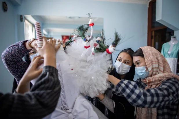 شابات أفغانيات يعملن على فستان زفاف بكابل في 8 نوفمبر 2022 وقد دعت «طالبان» أصحاب قاعات الأفراح في كابل مرة أخرى إلى الامتناع عن عزف الموسيقى والأنشطة التي تتعارض مع أحكامها المتعلقة بحفلات الزفاف أو المناسبات المماثلة (د.ب.أ)