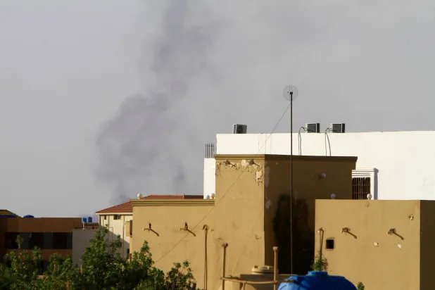 الدخان يتصاعد خلف المباني في الخرطوم (أ.ف.ب)