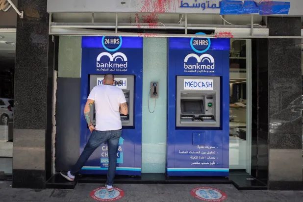 Beyrut’ta ATM’lerden birinde mevduat hesabından para çekmeye çalışan biri (Getty Images)