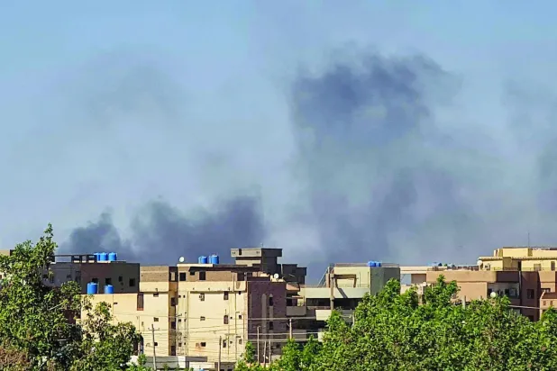 سوڈانی دارالحکومت کے ایک محلے میں عمارتوں کے پیچھے سے دھواں اٹھ رہا ہے (اے ایف پی)