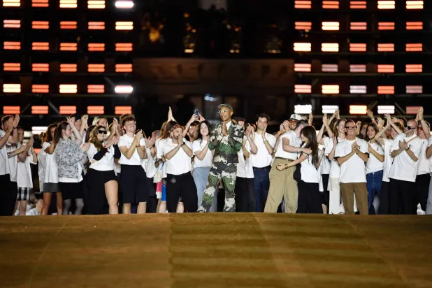 فاريل ويليامز مع فريق عمله يحيي ضيوفه بعد العرض (أ.ف.ب)