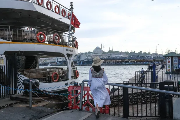 سائحة تقف عند مرفأ العبارات في مدينة إسطنبول التركية... بينما تترقب جميع الأوساط الاقتصادية أول اجتماع للبنك المركزي برئاسة حفيظة غايا إركان (إ.ب.أ)