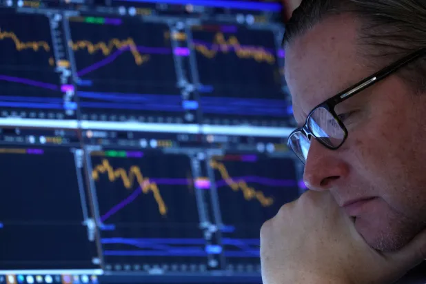 أحد العاملين في بورصة وول ستريت يراقب حركة الأسهم الهابطة فيما تراجعت الأسواق الخميس عقب إصرار «الفيدرالي» على مسار التشديد (رويترز)