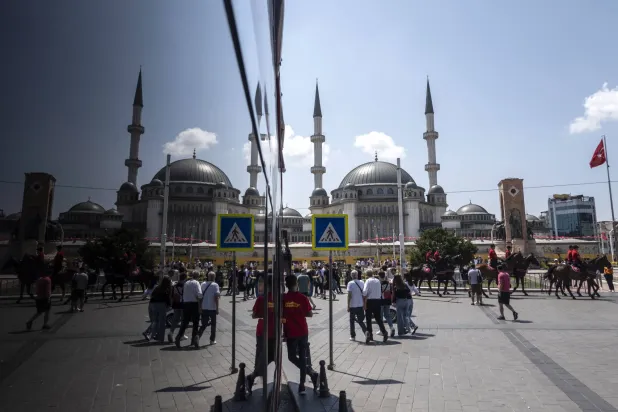 مشاة في شارع تقسيم التجاري وسط مدينة إسطنبول التركية فيما تعهد وزير المالية بتحقيق الاستقرار على المدى القصير (إ.ب.أ)