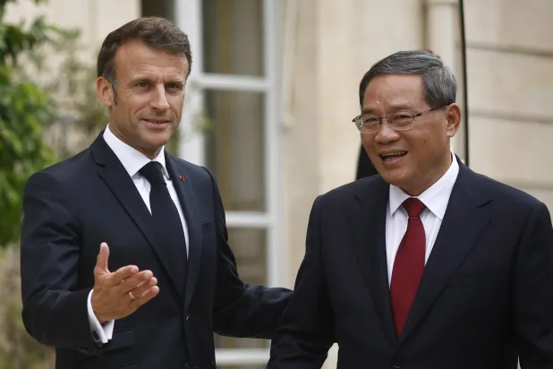 رئيس الوزراء الصيني لي تشيانغ (يمين) والرئيس الفرنسي إيمانويل ماكرون (يسار) (إ.ب.أ)
