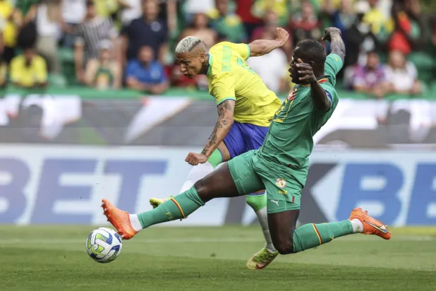 كوليبالي في صراع على الكرة مع ريتشارلسون لاعب منتخب البرازيل (إ.ب.أ)