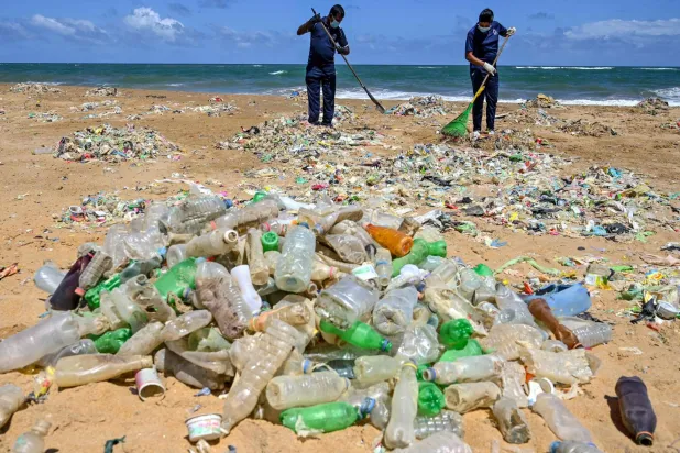 تنظيف أحد الشواطئ من النفايات وقناني البلاستيك الفارغة في كولومبو بسريلانكا (أ.ف.ب)