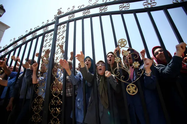 أعضاء من «مجاهدي خلق» أمام مدخل معسكر «أشرف 3» قرب العاصمة الألبانية تيرانا الأسبوع الماضي (أ.ف.ب)