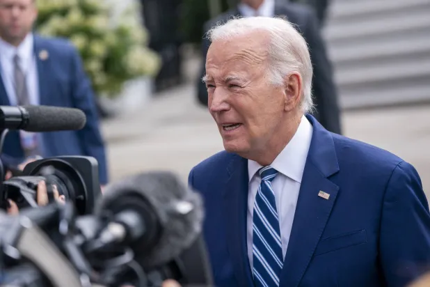 الرئيس الأميركي جو بايدن يرد على سؤال من وسائل الإعلام بينما يسير ليستقل طائرة تقله من البيت الأبيض إلى مدينة شيكاغو في 28 يونيو 2023 (إ.ب.أ)