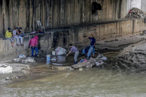 Lübnan’ın kuzeyindeki Trablusşam şehrinde, Ebu Ali Nehri kıyısındaki atıklarla ihtiyaçlarını karşılamaya çalışan Lübnanlılar. (AP)