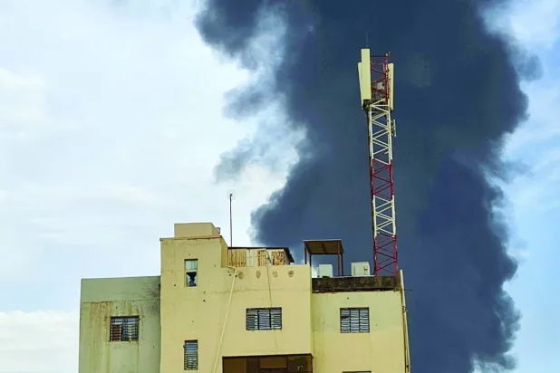 Hartum’un güneyinde bir binanın arkasındaki çatışma yansımaları (AFP)