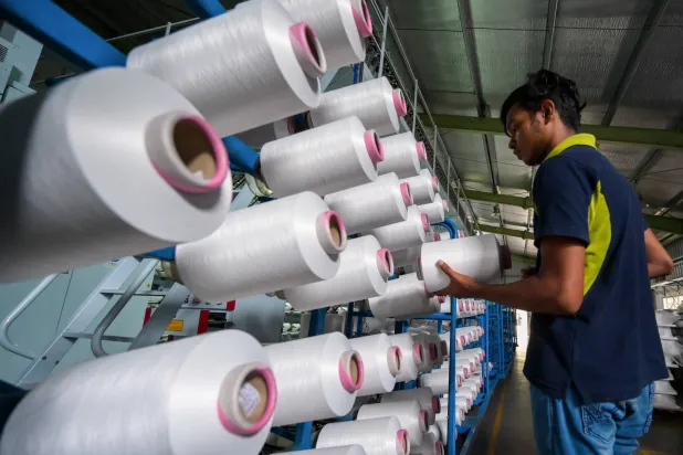 عامل يضع بكرة من خيوط النايلون المعاد تدويره في أكبر منشأة لإعادة تدوير البلاستيك في سريلانكا (أ.ف.ب)