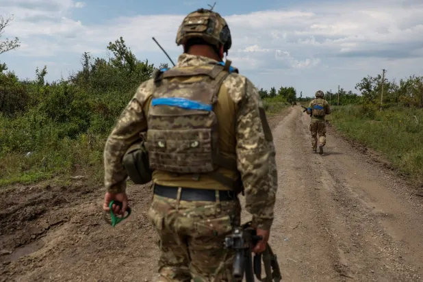 جندي أوكراني يتجول داخل بلدة أُعيدت السيطرة عليها وسط الغزو الروسي للبلاد (رويترز)