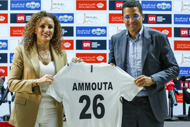 مدرب منتخب الأردن عموتة حاملاً قميص منتخب النشامى مع سمر نصار أمين الاتحاد (الاتحاد الأردني)