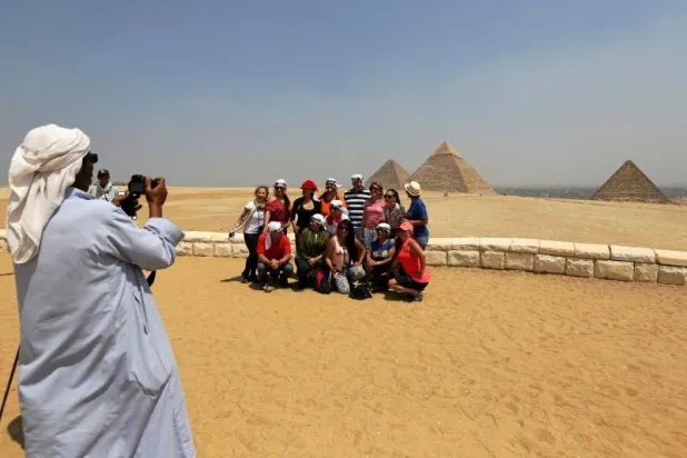 Tourists take a photo in front of the Great Giza pyramids on the outskirts of Cairo (Reuters)

