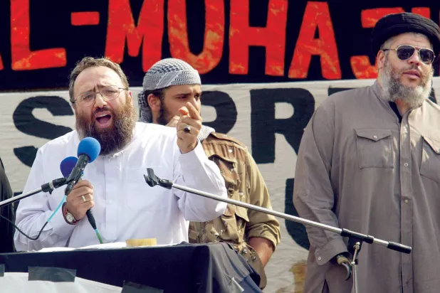 عمر بكري يلقي كلمة في مؤتمر لجماعة إسلامية متشددة وبجواره أبو حمزة المصري (غيتي)