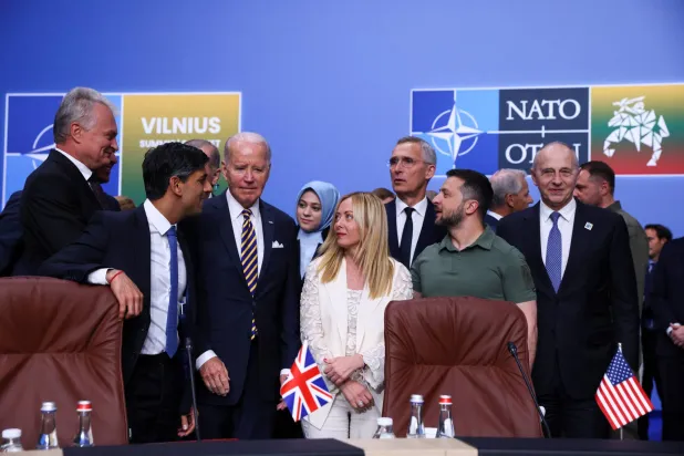 عدد من قادة دول حلف الناتو بما فيهم الرئيس الأميركي جو بايدن مع الرئيس الأوكراني فولوديمير زيلينسكي خلال اجتماع ضمن قمة قادة الناتو في فيلنيوس بليتوانيا في 12 يوليو 2023 (رويترز)