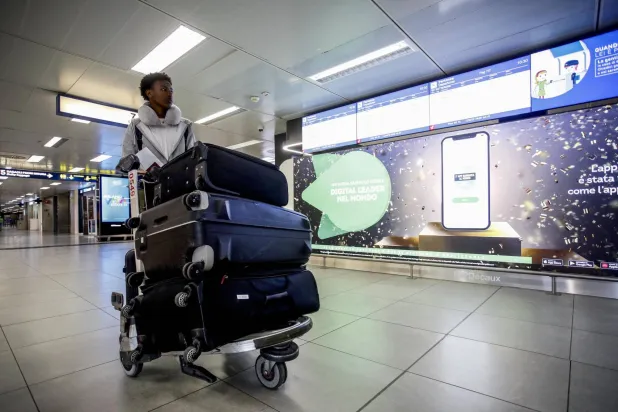 راكب ينتظر في مطار ميلانو أثناء إضراب عمال النقل الجوي (إ.ب.أ)