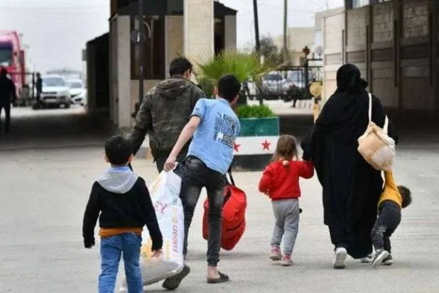 عائلة سورية تعود عبر معبر الحمام بريف جنديرس في عفرين (المرصد السوري)