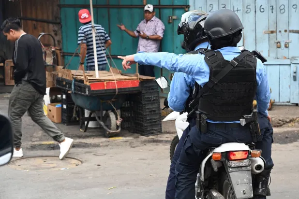 عنصران من شرطة هندوراس خلال عملية أمنية (أ.ف.ب)