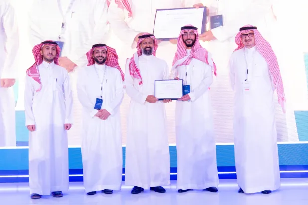 القويز يسلم شهادة لأحد المتدربين خلال الحفل الختامي لمعسكر التقنية المالية (الشرق الأوسط)